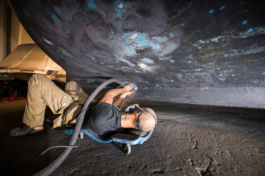 Technician worker fixing boat hull at workshop