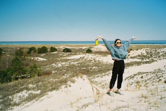 Young woman in dunes opposite the ocean