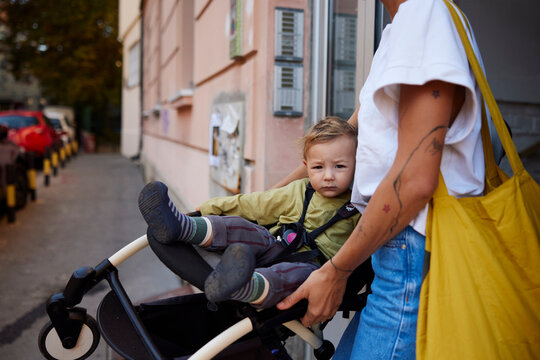 Portrait of a mother carrying a stroller with a boy