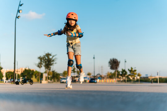 Determined girl riding roller skates in town