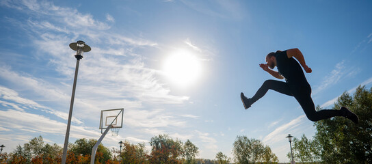 Caucasian man jumping with high hip raise outdoors. 