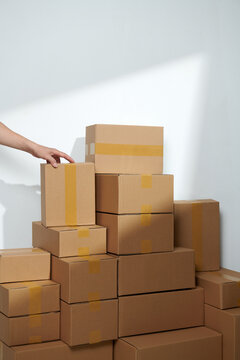 hand holding carton put on stack of boxes