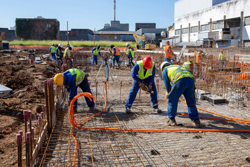 Construction workers during installation of steel gratings for the foundation of a building. Sao...