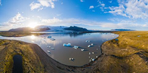 Aerial view on Fjallsarlon, a glacial lake with small icebergs floating in the water in front of...