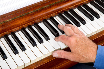 closeup of a male pianist playing the piano with his fingers on the keys around middle C
