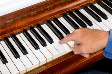 closeup of a male pianist playing the piano with his fingers on the keys around middle C