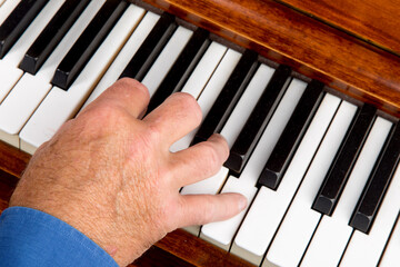 closeup of a male pianist playing the piano with his fingers paying a C cord