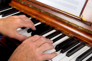 closeup of a male pianist playing the piano with his fingers on the keys around middle C with blank...