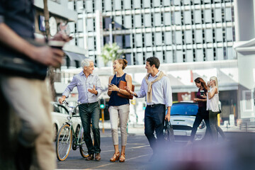 Diverse business people laughing while walking to work