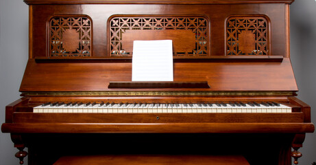 an old rosewood piano with blank sheet music staff paper
