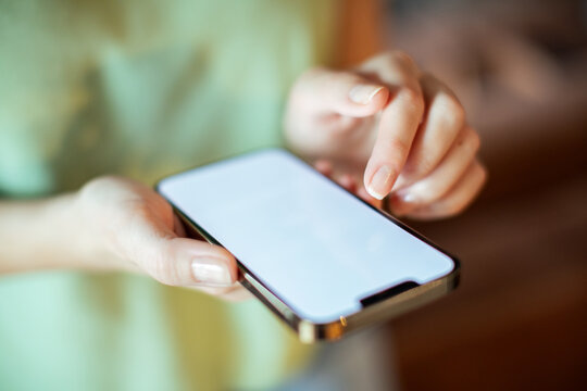 Top view of woman holding smartphone with blank screen