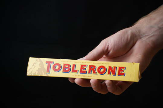 LVIV, UKRAINE - September 4, 2023:Toblerone chocolate bar in hand on a black background
