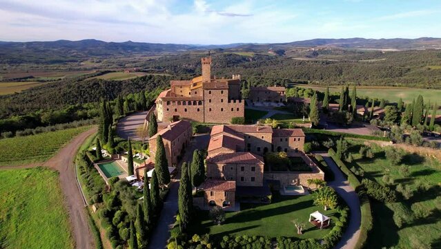 Golden vineyards of Tuscany. Aerial drone view , panorama of medieval castle and hotel - Castello di Banfi. Italy, Toscana scenery high angle aerial drone video
