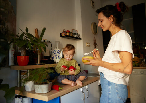 Woman feeds the boy with porridge