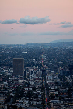 A plane flying over Los Angeles at sunset