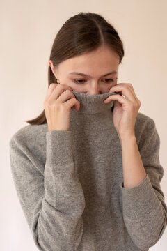 Woman hides her face with a sweater