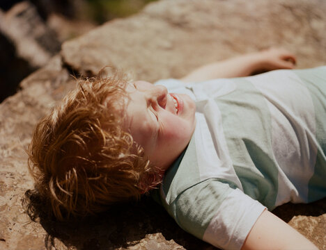 A funny child lying on a stone