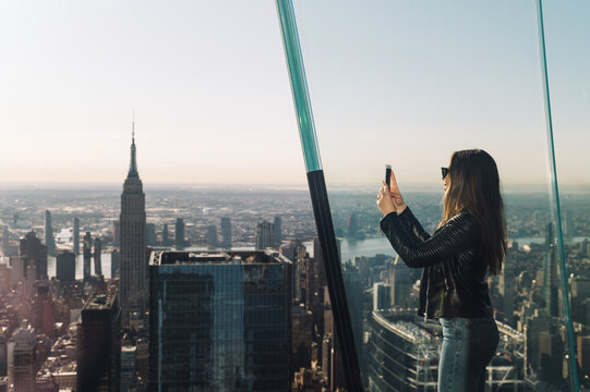 Woman capturing Manhattan skyline from observation deck