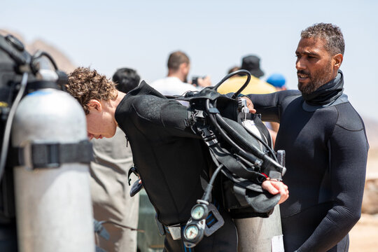 Divemaster assisting student with Scuba Diving Gear