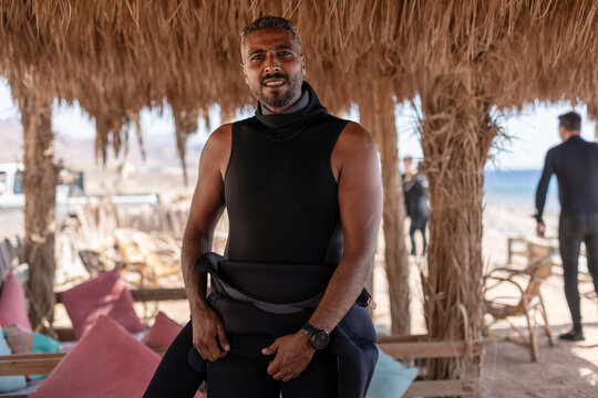 Portrait of a man putting on wetsuit