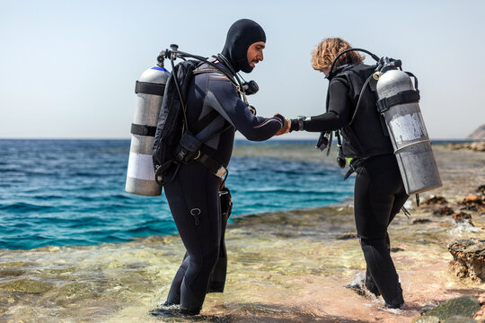 DIvemaster assisting scuba diver
