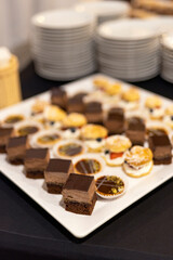 Tray with pieces of different kinds of chocolate and fruit cakes on the table for celebration or Christmas and New Year