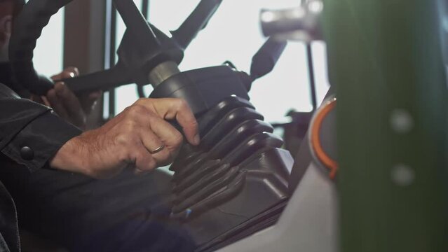 Tractor driver shifting the gearbox lever 