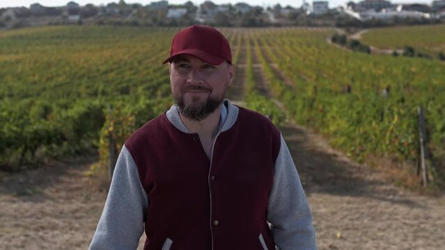 Winegrower smiles and moves through the vineyard 