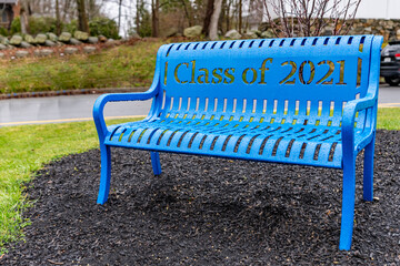 Powder coated blue metal bench with class of 2021 text on back rest.
