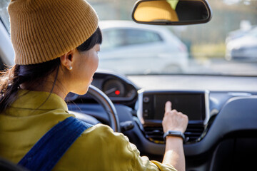 Woman using GPS navigator while driving car in city