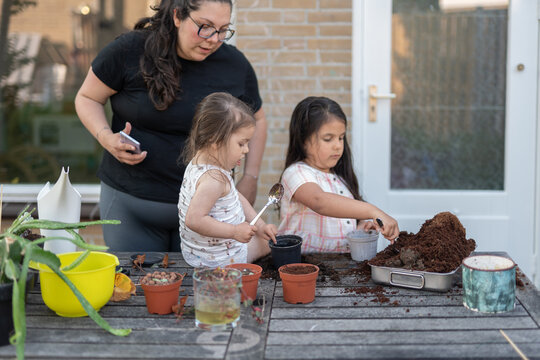 family planting seedlings in pots