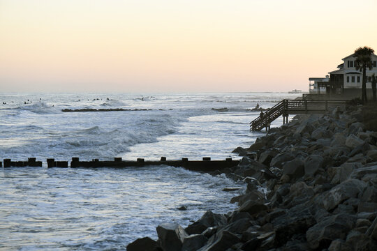 A Row Of Surfers At High Tide