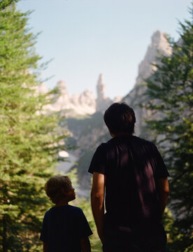Father and son in the mountains enjoy the view