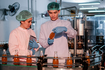 Specialist in factory checking bottles. Two female worker inspecting quality of plastic water tank on conveyor belt in drinking water factory.