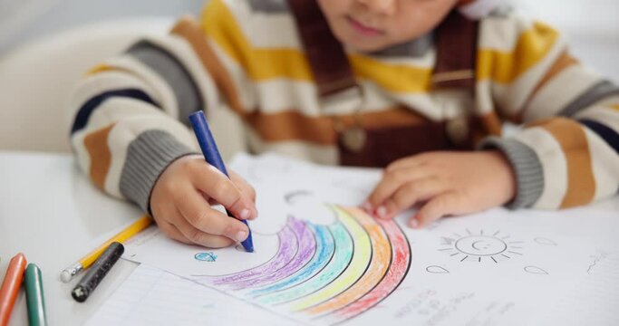 Children, drawing and crayons for art creativity or learning development in home as student, learn or rainbow. Kid, hand and coloring picture on paper for homework activity or lesson, skill or youth