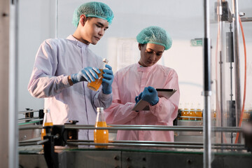 Specialist in factory checking bottles. Two female worker inspecting quality of plastic water tank on conveyor belt in drinking water factory.