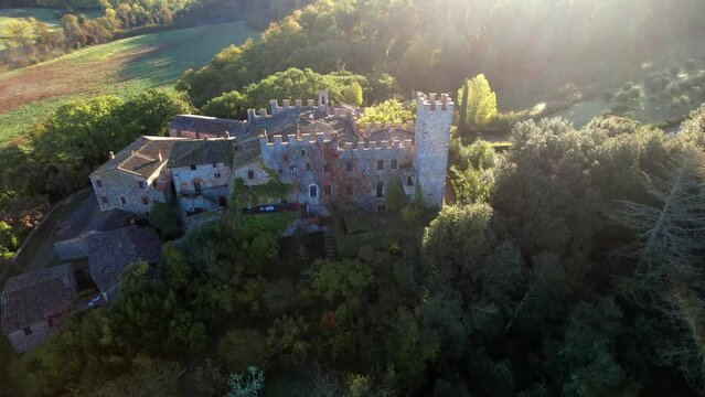 The castle and medieval village of Montalto in Chianti, Italy, known as ‘la Berardenga’. aerial drone video on the sunrise. Scenic Italian landscape