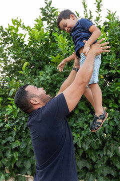 latin father with little son playing outdoors