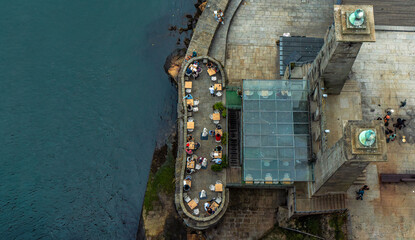 Aerial overhead view of people and tourists sitting on the terrace of a bar on the Porto seafront...