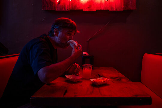 Man eating some tacos and Drinking Beer On A Bar 