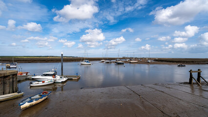 Boats moored in the estuary in the seaside town of Wells on the North Norfolk coast - obrazy, fototapety, plakaty
