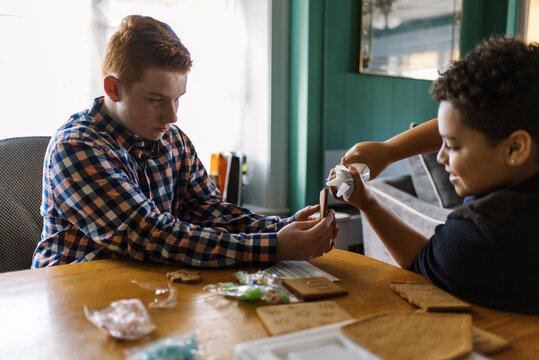 brothers making a gingerbread house together 
