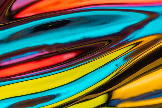 Abstraction of multicolored mirror waves of metallic texture