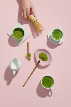 Preparing matcha latte beverage on pink background