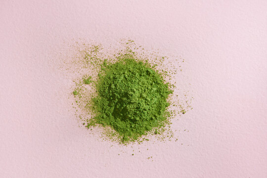 Matcha powder explosion on pink background from above