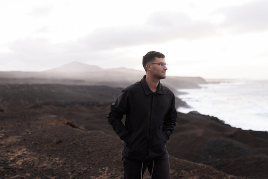 Man takes a leisurely walk, admiring the cliffs and sea horizon