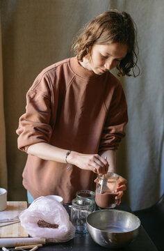 
Girl stirs enamel to coat pottery