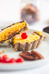 Delicious Gourmet Chocolate-Covered Pecan Pie with a Vibrant Orange Filling