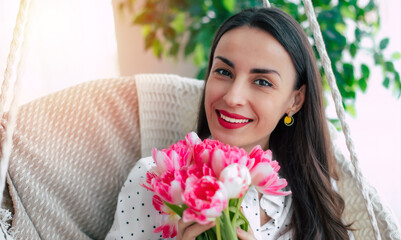 Close up portrait of gorgeous smiling girl with bouquet of pink flowers is looking on the camera. Tulips in women's day with love. St. Valentines day, March 8, Birthday - 771004262
