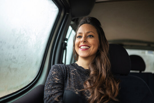 portrait of elegant young woman traveling by car on a rainy day